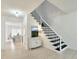 Bright foyer with staircase, white walls, and view into kitchen with marble island at 129 Grande Dr, Morrisville, NC 27560