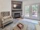 Cozy living room featuring a fireplace, TV, comfortable seating, and natural light from the doors to a deck at 129 Grande Dr, Morrisville, NC 27560