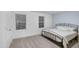 A light-filled bedroom with a metal bed frame, two windows, and neutral carpeting at 1534 Millrock Trl, Wendell, NC 27591