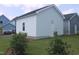 Detached garage with light blue siding and white door, with green bushes at 1534 Millrock Trl, Wendell, NC 27591