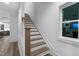 A wood and white staircase featuring a window and access to the home's kitchen at 1534 Millrock Trl, Wendell, NC 27591