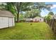 Spacious backyard featuring a wooden deck, a shed, lush lawn, mature trees, and a wood fence at 1826 Northgate St, Durham, NC 27704