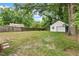 Overgrown backyard featuring a detached garage and bordered by a wood fence at 1826 Northgate St, Durham, NC 27704
