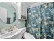 Well-lit bathroom with a round mirror and white vanity offering efficient storage solutions at 1826 Northgate St, Durham, NC 27704