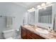 Bathroom featuring dual sinks with granite countertops, a toilet, and a large mirror, providing plenty of space at 1826 Northgate St, Durham, NC 27704