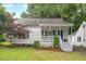Charming home with a welcoming porch, a blue door, white columns, and updated landscaping at 1826 Northgate St, Durham, NC 27704