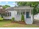 Charming home with a welcoming porch, a blue door, white columns, and updated landscaping at 1826 Northgate St, Durham, NC 27704