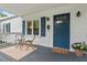 Inviting front porch with a cozy seating area and a vibrant blue door. Perfect for relaxing outdoors at 1826 Northgate St, Durham, NC 27704