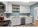 Well-lit kitchen featuring white cabinets, a stainless steel dishwasher, and quartz countertops at 1826 Northgate St, Durham, NC 27704