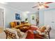 Living room with a warm color palette, comfortable seating, and a ceiling fan at 1826 Northgate St, Durham, NC 27704