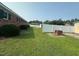Backyard features green grass, perimeter fence, and brick barbecue stand at 202 Camelia Dr, Princeton, NC 27569