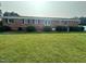 Well-maintained brick exterior with large, verdant bushes lining the back of the property at 202 Camelia Dr, Princeton, NC 27569
