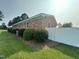 Well-maintained brick exterior with trimmed bushes and a white fence at 202 Camelia Dr, Princeton, NC 27569