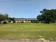 Traditional brick home with a large front yard, mature trees, and a covered side carport at 202 Camelia Dr, Princeton, NC 27569