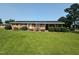 Charming one-story brick home with well-maintained lawn, trimmed shrubs, and a covered carport at 202 Camelia Dr, Princeton, NC 27569
