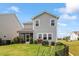 Well-maintained backyard featuring a charming garden, lush green grass, and an inviting screened porch at 209 Sage Oak Ln, Holly Springs, NC 27540