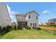 Fenced backyard with a covered patio, lush green grass, and landscaping at 209 Sage Oak Ln, Holly Springs, NC 27540