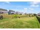 Expansive backyard with lush green grass, a black metal fence, and an inviting space for outdoor activities at 209 Sage Oak Ln, Holly Springs, NC 27540