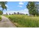 Scenic view of the community, featuring rolling hills, a lush green lawn, and an elegant clubhouse at 209 Sage Oak Ln, Holly Springs, NC 27540