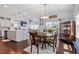 Sunlit dining area features dark wood floors, decorative chandelier, and access to the backyard at 209 Sage Oak Ln, Holly Springs, NC 27540