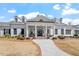 Beautiful, white, single story home with symmetrical columns and landscaping and a brick walkway at 209 Sage Oak Ln, Holly Springs, NC 27540