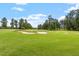 Bunker on the golf course with manicured lawns surrounded by lush trees on a sunny day at 209 Sage Oak Ln, Holly Springs, NC 27540