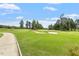 Scenic golf course with lush green fairways and mature trees under a beautiful blue sky at 209 Sage Oak Ln, Holly Springs, NC 27540