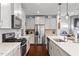 Contemporary kitchen with stainless steel appliances, white countertops, and ample storage space at 209 Sage Oak Ln, Holly Springs, NC 27540