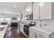 Well-lit kitchen with stainless appliances, stone tile backsplash, and adjacent dining area at 209 Sage Oak Ln, Holly Springs, NC 27540