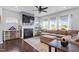 Bright living room with fireplace, large windows, dark wood floors, and neutral paint at 209 Sage Oak Ln, Holly Springs, NC 27540