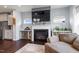 Cozy living room with a fireplace, mounted television, and adjacent kitchen area at 209 Sage Oak Ln, Holly Springs, NC 27540