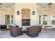 Covered outdoor patio with a fireplace and four wicker chairs. Basket art above the fireplace at 209 Sage Oak Ln, Holly Springs, NC 27540