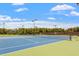 Well-maintained tennis courts featuring blue and green surfaces with surrounding trees and lighting at 209 Sage Oak Ln, Holly Springs, NC 27540