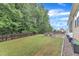 Expansive backyard featuring green grass, a stone patio, and privacy fencing, offering a private outdoor space at 216 Pondside Dr, Apex, NC 27539