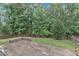 Lush backyard with a well-maintained lawn, a charming stone patio and mature trees, perfect for outdoor entertaining at 216 Pondside Dr, Apex, NC 27539