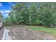Spacious backyard with a stone patio, lush lawn, and privacy fence, creating a serene outdoor environment at 216 Pondside Dr, Apex, NC 27539
