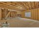 Unfinished basement with exposed beams, natural light, and wooden subflooring at 216 Pondside Dr, Apex, NC 27539