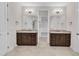 Elegant bathroom with double vanities, framed mirrors, granite countertops, and access to walk-in closet at 216 Pondside Dr, Apex, NC 27539