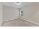 This bedroom has neutral-colored carpet, light walls, and a window at 216 Pondside Dr, Apex, NC 27539