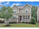 Inviting home exterior with stone accents, a covered front porch, and a lush green lawn at 216 Pondside Dr, Apex, NC 27539