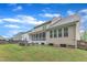 Rear exterior view of the home showing the screened porch, stone patio, and backyard, ideal for outdoor enjoyment at 216 Pondside Dr, Apex, NC 27539