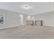 Spacious living room with carpet, light walls, and dark wood staircase at 216 Pondside Dr, Apex, NC 27539