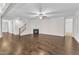 Bright living room features hardwood floors, fireplace, ceiling fan, and staircase at 216 Pondside Dr, Apex, NC 27539