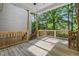 View of a covered back porch with wood railing and lush green background at 2623 Broad Oaks Pl, Raleigh, NC 27603