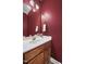 A small bathroom featuring a white sink and a striking dark red painted wall at 2623 Broad Oaks Pl, Raleigh, NC 27603