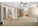 Large carpeted main bedroom with ceiling fan, neutral paint, and ensuite bathroom and walk-in closet at 2623 Broad Oaks Pl, Raleigh, NC 27603
