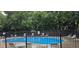 Community pool with lounge chairs, safety fence, and mature green trees at 2623 Broad Oaks Pl, Raleigh, NC 27603