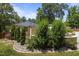 A stone-lined flower bed hosts shrubbery and evergreen trees along the side of the home at 2710 Broad St, Durham, NC 27704