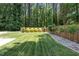 A large lawn is lined with a wooden fence and a stone border at 2710 Broad St, Durham, NC 27704