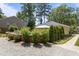 A charming yard with a gravel area, stone-lined raised flower beds, and lush trees providing ample shade at 2710 Broad St, Durham, NC 27704